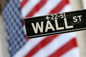 FILE - In this Sept. 8, 2015, file photo, a Wall Street street sign is framed by a giant American flag hanging on the facade of the New York Stock Exchange. European stock markets recovered their poise Tuesday, Sept. 29, 2015, despite an earlier rout in Asia which featured a 4 percent slide in Japans main index. (AP Photo/Mary Altaffer, File)