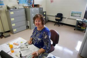 In this Wednesday, Sept. 2, 2015 photo high school nurse Kathleen Gage, instrumental in working for the accepted use of Narcan in Rhode Island schools, sits at her desk at Pilgrim High School Wednesday, Sept. 2, 2015, in Warwick, R.I. A new state law requires middle schools and high schools to stock Narcan, which can reverse the effects of an overdose of drugs such as heroin or prescription painkillers. (AP Photo/Stephan Savoia)
