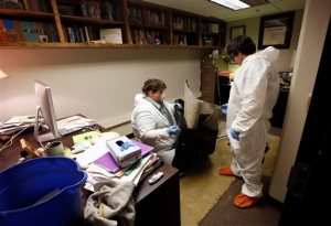 An environmental cleanup crew works in the office of Delta State University history professor Ethan Schmidt in Cleveland, Miss., on Tuesday, Sept. 15, 2015. Police say Shannon Lamb, an instructor at the same school, killed Schmidt in his office Monday morning. Lamb later died in Greenville of an apparent self-inflicted gunshot wound. (AP Photo/Rogelio V. Solis)