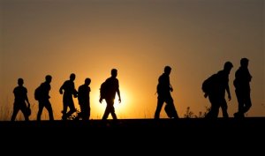 A group of refugees walk on the railway tracks after crossing from Serbia, in Roszke, Hungary, Tuesday, Sept. 1, 2015.  Migrants fearful of death at sea in overcrowded and flimsy boats have increasingly turned to using a land route towards Europe through the Western Balkans.  (AP Photo/Darko Bandic)