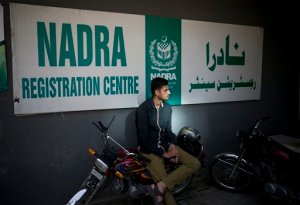 In this Monday, Aug. 24, 2015 photo, a Pakistani applicant waits outside the office of Pakistans National Data Registration Authority or NADRA to collect their identity cards in Islamabad, Pakistan. Foreign Islamic militants have been able to secure Pakistani national identity cards in exchange for bribes as low as $100, giving them vastly greater freedom to operate, according to a report by Pakistans top intelligence agency obtained by The Associated Press. The main fault in the ID scandal seems to lies with corruption in Pakistans NADRA, the organization that issues national ID cards. (AP Photo/B.K. Bangash)