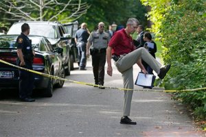 South Lake Minnetonka interim Police Chief Michael Siitari, right, climbs over the police tape to address the media Thursday, Sept. 10, 2015 in Greenwood, Minn. after five family members, including three children, were found dead in their lakeside home in an upscale western Minneapolis suburb on Thursday in what police said appeared to be a murder-suicide. (AP Photo/Jim Mone)
