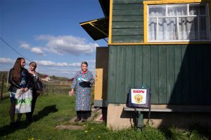 Nina Korneyeva, 74, prepares to cast her ballot in a ballot box that election officials, left, have brought to villagers unable to travel to the polling station, in the village of Seltso, near Kostroma, 350 km (218 miles) northeast of Moscow, Russia, Sunday, Sept. 13, 2015. Voters are casting ballots across Russia for local legislators and governors, in elections expected to be won by candidates loyal to President Vladimir Putin. Sundays elections are being seen as a dress rehearsal for next years vote for a national parliament, and the anti-Putin opposition was allowed to run in only one Russian region, Kostroma. (AP Photo/Pavel Golovkin)