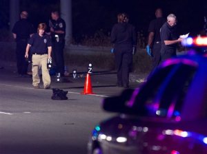 Investigators survey the scene where an off-duty police officer fatally struck a pedestrian with his cruiser Thursday, Sept. 25, 2015 in Indianapolis.  Police spokesman Lt. Richard Riddle said the incident happened just before midnight Thursday. The officer stopped after striking the man and got out to help, performing chest compressions, Riddle said. The victim was declared dead at the scene.  (Michael Anthony Adams /The Indianapolis Star via AP)  NO SALES; MANDATORY CREDIT