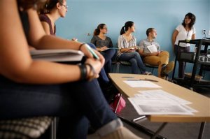 In this Wednesday, Sept. 16, 2015, photo, Anna Reyna, right, supervisor of the counseling department at The Door, teaches a class on adolescent development at the youth services organization, in New York. New York City is embarking on a $30 million plan to prepare to staffers at social service organizations to screen people for possible psychological problems, provide information and try to motivate them to make changes in their lives. (AP Photo/Seth Wenig)