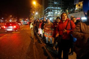 A police officer stands in the street to flag down buses for people to take home after an earthquake in Santiago, Chile, Wednesday, Sept. 16, 2015. A powerful magnitude-8.3 earthquake hit off Chile's northern coast Wednesday night, causing buildings to sway in Santiago and other cities and sending people running into the streets. (AP Photo/Luis Hidalgo)