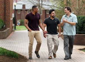 ADVANCE FOR RELEASE SUNDAY, AUG. 30, 2015, AT 9:00 A.M. EDT. AND THEREAFTER - In this April, 3, 2015 photo, Joe Boucher, right, a former producer for "The Simpsons" and "King of the Hill," walks on campus with Roanoke College students, Omaria Chancellor, left, and Andrew Miller Jr. in Roanoke, Va. Boucher graduated from Roanoke College in 1987 and came back to his alma mater in his new role as director of student activities and campus center. (Heather Rousseau/The Roanoke Times via AP) LOCAL TELEVISION OUT; SALEM TIMES REGISTER OUT; FINCASTLE HERALD OUT; CHRISTIANBURG NEWS MESSENGER OUT; RADFORD NEWS JOURNAL OUT; ROANOKE STAR SENTINEL OUT; MANDATORY CREDIT