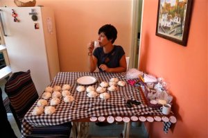 In this Aug. 26, 2015 photo, Sandra Aldama takes a break while wrapping bars of home made soap in Havana, Cuba. The church is operating in ways unimaginable in the years when the state tried to control every aspect of life in Cuba, such as the entrepreneurial training programs that imparted skills from accounting to business development that helped the Aldama family business. (AP Photo/Desmond Boylan)