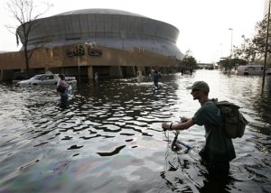 FILE - This Aug, 31, 2005 file photo shows a man pushing his bicycle through flood waters near the Superdome in  New Orleans after Hurricane Katrina left much of the city under water. A new but controversial study asks if an end is coming to the busy Atlantic hurricane seasons of recent decades. The Atlantic looks like it is entering in to a new quieter cycle of storm activity, like in the 1970s and 1980s, two prominent hurricane researchers wrote Monday in the journal Nature Geoscience.(AP Photo/Eric Gay, File)