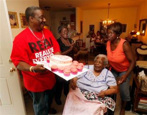 FILE- In this July 25, 2015, file photo, Terrance Jackson, left, Doris Ware, second from left, and Beverly Booker, right, sing "Happy Birthday To You" to Bernice Williams, seated, as she celebrates her 103rd birthday in the Mill City neighborhood of Dallas. The music publishing company that has been collecting royalties on the song "Happy Birthday To You" for years does not hold a valid copyright on the lyrics to the tune that is one of the mostly widely sung in the world, a federal judge ruled Tuesday, Sept. 22, 2015 (Michael Ainsworth/The Dallas Morning News via AP, File) MANDATORY CREDIT; MAGS OUT; TV OUT; INTERNET USE BY AP MEMBERS ONLY; NO SALES
