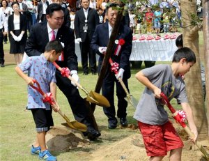Noraha Mayor Yukiei Matsumoto, rear left, plants a tree with children of Naraha residents during an event in Naraha, Fukushima, northern Japan, Saturday, Sept. 5, 2015. The Japanese town of Naraha on Saturday lifted a 2011 evacuation order that sent all its 7,400 residents away after the nearby Fukushima nuclear plant was crippled by a tsunami and spread contamination. (AP Photo/Koji Sasahara)