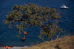 An inflatable dinghy full of migrants is towed by another while a Greek coast guard vessel monitors their approach to the shores of the Greek island of Lesbos after crossing the Aegean Sea from Turkey to Greece, Monday, Sept. 21, 2015. Greece's coast guard was searching Sunday for 26 migrants missing off the coast of the eastern Aegean island of Lesbos after the boat they were traveling in sank.(AP Photo/Petros Giannakouris)