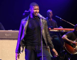 FILE - In this Aug. 8, 2015, file photo, Usher performs during the 2015 Ford Neighborhood Awards at Philips Arena in Atlanta. Usher, Laverne Cox and Katie Holmes have been added to the Global Citizen Festival on Sept. 26, 2015, starring Beyonce and Pearl Jam in New York City. (Photo by Robb D. Cohen/Invision/AP, File)