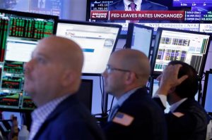 Traders work in a booth on the floor of the New York Stock Exchange, Thursday, Sept. 17, 2015. The Federal Reserve is keeping U.S. interest rates at record lows in the face of threats from a weak global economy, persistently low inflation and unstable financial markets. (AP Photo/Richard Drew)