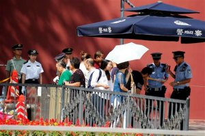FILE - In this Aug. 27, 2015 file photo, Chinese policemen check identifications of a passerby ahead of the Sept. 3 massive military parade commemorating the end of World War II in Beijing. China will hold a massive military parade through the heart of its capital, but ordinary folks cant watch. Authorities obsessed with security and leery of any possible hitches will virtually shut down central Beijing on Thursday, Sept. 3, keeping most people out of eyeshot for the parade commemorating the defeat of Japan in World War II. Residents who live along the parade route have received notices ordering them to stay off balconies, keep windows shut, invite no guests and - at some buildings - snap no pictures. (AP Photo/Ng Han Guan, File)
