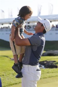 Jason Day of Australia, celebrates winning the BMW Championship with his son, Dash, after the final round of the golf tournament at Conway Farms Golf Club, Sunday, Sept. 20, 2015, in Lake Forest, Ill. (AP Photo/Charles Rex Arbogast)