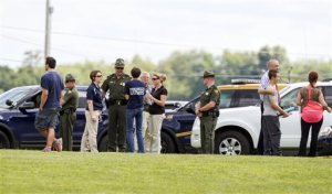 West Virginia Police and school officials help parents reunite with their children at Philip Barbour High School following a "hostage-type situation" Tuesday, Aug. 25, 2015, in Philippi, W.Va. A report of someone with a gun inside the school led authorities to isolate and arrest a suspect in the building Tuesday, State Police said. (AP Photo/Ben Queen)