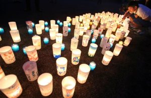 A man lights candles during a candle light installation event in Naraha, Fukushima, northern Japan, Friday, Sept. 4, 2015. Residents of Naraha will returns from Saturday to live in the town near the Fukushima nuclear power plant for the first time since the 2011 disaster. (AP Photo/Koji Sasahara)