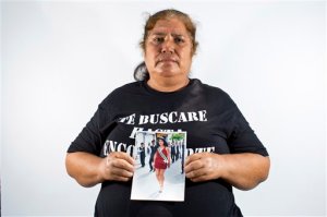 In this May 26, 2015 photo, Rosa Segura Giral holds up a photo of her daughter, Berenice Navarijo Segura, in Iguala, Mexico. On the morning of her high school graduation, 19-year-old Berenice left for a beauty salon appointment, less than a five-minute drive from home, and vanished into the ranks of Mexicos missing. Segura Giral says she has not lost hope for her daughter. (AP Photo/Dario Lopez-Mills)