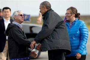 President Barack Obama is greeted by Mayor Maija Lukin, right, and Northwest Arctic Borough Mayor Reggie Joule, left, as he arrives at Ralph Wien Memorial Airport, Wednesday, Sept. 2, 2015, in Kotzebue, Alaska. Obama is on a historic three-day trip to Alaska aimed at showing solidarity with a state often overlooked by Washington, while using its glorious but changing landscape as an urgent call to action on climate change. (AP Photo/Andrew Harnik)