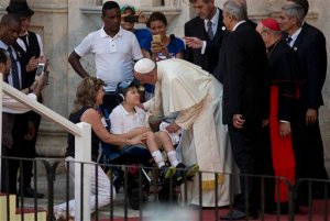 Pope Francis greets a child on a wheelchair during a meeting with a group of Cuban youth in Havana, Cuba, Sunday Sept. 20, 2015. Pope Francis met with Fidel Castro on Sunday before finishing the day with a vespers service in Havana's cathedral, and then meeting with the youths. (AP Photo/Ramon Espinosa)