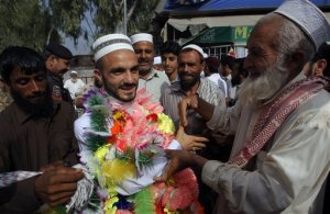 A Pakistani man, center left, is greeted by relatives on his arrival from Saudi Arabia after performing the Muslim hajj pilgrimage, Monday, Sept. 28, 2015 in Peshawar, Pakistan. Pakistan's minister for religious affairs says authorities have tracked down 217 Pakistanis who went missing following last week's stampede that killed more than 700 pilgrims during the hajj in Saudi Arabia. (AP Photo/Mohammad Sajjad)