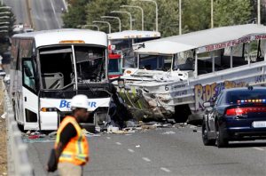 An emergency official stands near a charter bus, left, and a "Ride the Ducks" amphibious tour bus that were involved in a fatal crash Thursday, Sept. 24, 2015, in Seattle. (AP Photo/Ted S. Warren)