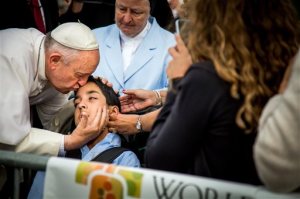 In this photo provided by World Meeting of Families, Pope Francis kisses and blesses Michael Keating, 10, of Elverson, Pa after arriving in Philadelphia and exiting his car when he saw the boy, Saturday, Sept. 26, 2015, at Philadelphia International Airport. Keating has cerebral palsy and is the son of Chuck Keating, director of the Bishop Shanahan High School band that performed at Pope Francis' airport arrival. (Joseph Gidjunis/World Meeting of Families via AP) MANDATORY CREDIT