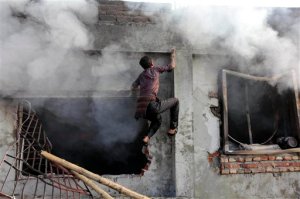 FILE  In this Saturday, Jan. 26, 2013 file photo, a Bangladeshi climbs a wall to get to the roof of a two-storied garment factory that caught fire killing at least six female workers in Dhaka, Bangladesh. Authorities in Bangladesh said during a five-day visit by a delegation of the U.S. Trade Representatives office ending Wednesday, Sept. 23, 2015, they have met a set of conditions put forward by the United States for better factory safety and workers rights that were essential to win back preferential trade status that the impoverished South Asian nation lost in 2013 after two deadly factory disasters. The collapse of Rana Plaza and a fire at another factory, Tazreen Fashions, that same year left about 1,500 workers dead and hundreds injured. The garment industry is crucial to Bangladeshs economy as it employs about 4 million workers, mostly rural women, and many other sectors including banks are heavily dependent on it. (AP Photo/A.M. Ahad, File)
