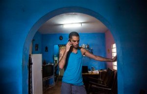 Danilo Maldonado, better known as El Sexto, speaks on a mobile phone in the living room of his home after being released from jail, in Havana, Cuba, Tuesday, Oct. 20, 2015. Maldonado was freed after 10 months behind bars for attempting to release two pigs painted with the names of Raul and Fidel Castro, the countrys current president and former leader. (AP Photo/Desmond Boylan)