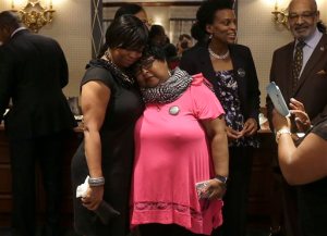Plaintiffs Lisa Johnson, left, hugs Deborah Neal before a news conference announcing the filing a lawsuit over their ejection from a Napa Valley Wine Train, Thursday, Oct. 1, 2015, in San Francisco. A group of mostly black women who were ejected from a Northern California wine country train this summer say they felt humiliated and can't believe they were treated that way in 2015. (AP Photo/Jeff Chiu)