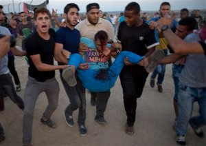 Palestinian protesters evacuate a wounded man during clashes with Israeli soldiers by the Israeli border with Gaza in Buriej, central Gaza Strip, Thursday, Oct. 15, 2015. (AP Photo/ Khalil Hamra)