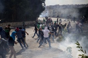 Palestinian students hurl stones at Israeli troops over the separation barrier during clashes following a protest near the Al-Quds University in the West Bank village of Abu Dis, near Jerusalem, Wednesday, Oct. 28, 2015. (AP Photo/Majdi Mohammed)