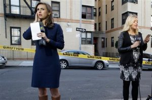 Television reporters report from across the street of an apartment building in the Bronx borough of New York, Thursday, Oct. 15, 2015. A 6-month-old girl died Thursday after being tossed from a window of the apartment building, witnesses and police said, the third child killed that way in the city in three months. (AP Photo/Mary Altaffer)