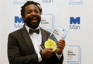 Jamaican author Marlon James holds the award after his book 'A Brief History of Seven Killings' was named as winner of the 2015 Booker Prize 2015 for Fiction, poses for photographers following the award ceremony at the Guildhall in London, Tuesday, Oct. 13, 2015.  Marlon James became the first Jamaican winner of the prestigious Booker Prize for fiction Tuesday with a vivid, violent, exuberant and expletive-laden novel based on the 1976 attempted assassination of Bob Marley.(AP Photo/Alastair Grant)