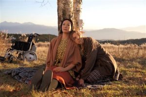 In this image created by (c)2015 "Sayonara" Production Committee and released by Phantom Film, a robot owner performed by American actress Bryerly Long, right, sits with her robot in a scene from Japanese director Koji Fukada's "Sayonara" shown at the Tokyo International Film Festival. The film set in Japan after a nuclear catastrophe depicts greed, discrimination, loyalty, beauty - traits made more heartbreakingly human by the casts inhuman star - a robot. The android, created by robot researcher Hiroshi Ishiguro, steals the show. The director Fukada refers to the robot as actress, and its listed as a member of the cast. (Phantom Film via AP) NO ARCHIVING; NO LICENSING; MANDATORY CREDIT