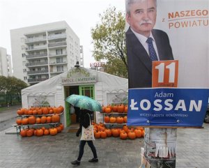 A woman walks past election posters  in Warsaw, Poland, Wednesday, Oct. 21, 2015. Parliamentary elections in Poland will take place on Oct. 25, with current opposition party, the conservative Law and Justice leading in polls. (AP Photo/Czarek Sokolowski)