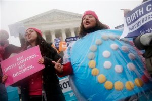FILE - In this March 25, 2015, file photo, protestors one wearing a birth control pills costume participate in a demonstration in front of the Supreme Court in Washington, as the court heard oral arguments in the challenges of President Barack Obama's health care law requirement that businesses provide their female employees with health insurance that includes access to contraceptives. Religion, birth control and the Obama health care overhaul are about to collide at the Supreme Court yet again. Faith-affiliated charities, colleges and hospitals that oppose some or all contraception as immoral are battling the Obama administration over rules that allow them to opt out of covering the contraceptives for women that are among a range of preventive services that must be included in health plans at no extra cost. (AP Photo/Charles Dharapak, File)