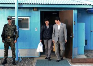 In this photo provided by the South Korean Unification Ministry, South Korean Won Moon Joo, center, who has a permanent resident status in the United States, is escorted by a South Korean official at the border village of Panmunjom in Paju, South Korea, Monday, Oct. 5, 2015. North Korea freed a South Korean national who'd been attending New York University before his detention, Seoul officials said Monday, in a possible sign Pyongyang wants better ties with rival Seoul and may back away from a recent threat to launch a long-range rocket later this month. (The South Korean Unification Ministry via AP)