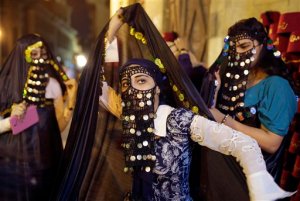 In this Wednesday, Sept. 23, 2015 picture, Egyptian girls wear ceremonial ancient clothes and "Yashmak", a veil concealing all of the face except the eyes, as they celebrate Eid al-Adha at El-Moez Street in historical Fatimid Cairo, Egypt. (AP Photo/Amr Nabil)