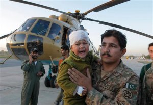 A Pakistani soldier carries an injured child who was airlifted from Chitral following Monday's deadly earthquake, at Peshawar airbase in Pakistan, Tuesday, Oct. 27, 2015. Rescuers are struggling to reach quake-stricken regions in Pakistan and Afghanistan on Tuesday as officials said the combined death toll from the previous day's earthquake rose to hundreds. (AP Photo/Mohammad Sajjad)