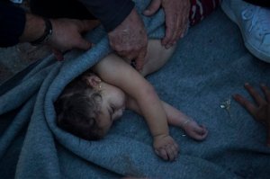 Paramedics and doctors try to revive a baby after a boat with refugees and migrants sank while crossing the Aegean sea from Turkey to the Greek island of Lesbos on Wednesday, Oct. 28, 2015. The condition of the child is not known. The Greek coast guard said it rescued 242 refugees or economic migrants off the eastern island of Lesbos Wednesday after the wooden boat they traveled in capsized, leaving at least three dead on a day when another 8 people drowned trying to reach Greece. (AP Photo/Santi Palacios)