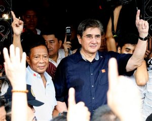 Philippine Vice-President and now presidential candidate Jejomar Binay, left, and running mate Senator Gregorio "Gringo" Honasan flash the No. 1 signs as they emerge from the Commission on Elections after filing their respective certificates of candidacy for next year's presidential elections Monday, Oct. 12, 2015 in Manila, Philippines. Binay and Honasan were the first candidates to file their candidacy before the Commission on Elections. (AP Photo/Bullit Marquez)