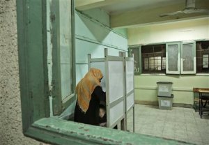 An Egyptian woman marks her ballot as her child peeks from the booth inside a polling station, during the first round of the parliamentary election, in the Boulaq El Dakrour district of Giza, near Cairo, Egypt, Sunday, Oct. 18, 2015. (AP Photo/Nariman El-Mofty)