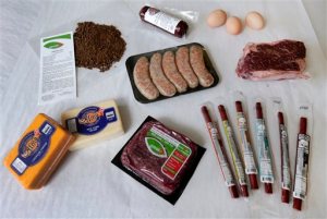 In this Oct. 1, 2015, photo, a variety of products with omega-3 fatty acids is shown at GreatO Premium Foods' facility in Manhattan, Kan. The company is has been experimenting with feeding a special flaxseed supplement, shown upper left, to cattle, chickens and pork to produce meat, egg, and dairy products with the healthy fat. (AP Photo/Charlie Riedel)
