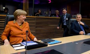 German Chancellor Angela Merkel, left, and Hungarian Prime Minister Viktor Orban, right, wait for the start of a round table meeting during an EU summit at EU headquarters in Brussels on Sunday, Oct. 25, 2015. EU leaders meet on Sunday to discuss refugee flows along the Western Balkans route. (AP Photo/Virginia Mayo)