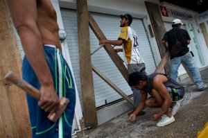 Men remove protective wood beams from the front of a business the morning after Hurricane Patricia passed further south sparing Puerto Vallarta, Mexico, Saturday, Oct. 24, 2015. The storm made landfall Friday evening on Mexico's Pacific coast as a Category 5 hurricane with maximum sustained winds of 165 mph (270 kph) but it is rapidly losing steam as it moves over a mountainous region inland from the shore.(AP Photo/Rebecca Blackwell)