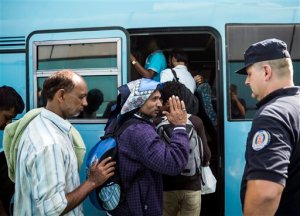 Migrants get on a bus towards Bezdan, near the Serbian-Croatian border at the closed border crossing between Serbia and Hungary, in Horgos, Serbia, Thursday, Sept. 17, 2015. Croatian leaders asked the army on Thursday to be on alert after chaos erupted at the border with Serbia, where thousands of migrants and refugees have poured into the country. Some trampled over each other in a rush to get on limited buses and trains, causing dozens of injuries amid the mayhem. (Balazs Mohai/MTI via AP)