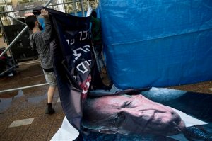 An Israeli worker hangs up a billboard with a portrait of late Israeli Prime Minister Yitzhak Rabin,  ahead of a memorial rally for the 20th anniversary of his assassination at Rabin square in Tel Aviv, Israel, Friday, Oct. 30, 2015. Twenty years after Yitzhak Rabin was gunned down by a Jewish extremist opposed to his negotiations with the Palestinians, Israel is more divided than ever over Mideast peacemaking _ and the people who opposed the assassinated premier with vitriol, led by Benjamin Netanyahu, now have a firm grip on power. (AP Photo/Oded Balilty