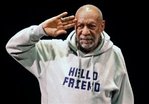 FILE - In this Jan. 17, 2015, file photo, comedian Bill Cosby salutes the crowd as he begins a performance at the Buell Theater in Denver. A year after allegations of sexual assault resurfaced and snowballed, women whove accused him of sexual assault are giving emotional interviews en masse, judges are ruling against him and colleges are continuing to revoke honorary degrees bestowed upon him when he was one of the countrys most admired entertainers. (AP Photo/Brennan Linsley, File)